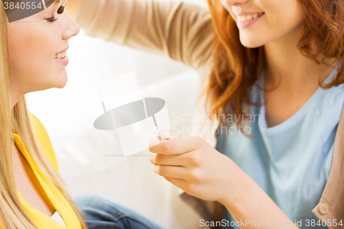 Image of woman visagist applying eyeshade by makeup brush 