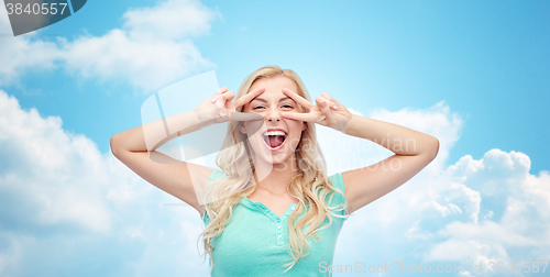 Image of smiling young woman or teenage girl showing peace