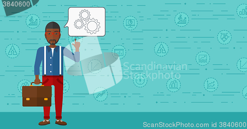 Image of Businessman pointing at cogwheels.