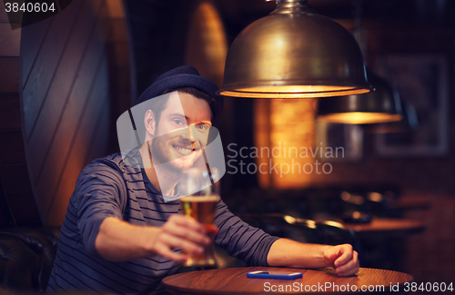 Image of happy man drinking beer at bar or pub