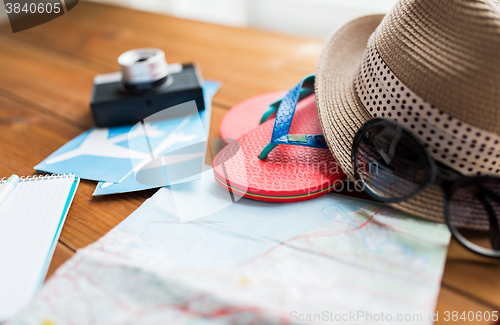 Image of close up of travel map, flip-flops, hat and ticket