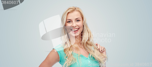 Image of smiling young woman holding her strand of hair