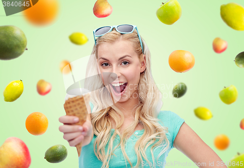 Image of happy young woman in sunglasses eating ice cream