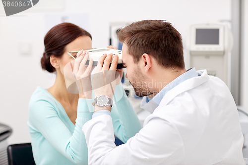 Image of optician with pupilometer and patient at eye clinic