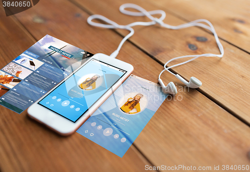 Image of close up of smartphone and earphones on wood