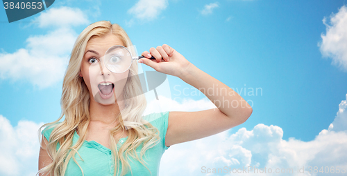 Image of happy young woman with magnifying glass