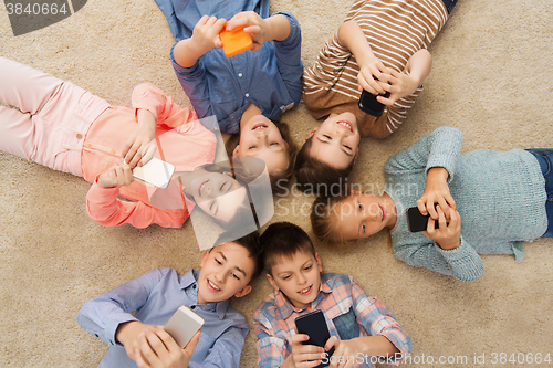 Image of happy smiling children lying on floor in circle