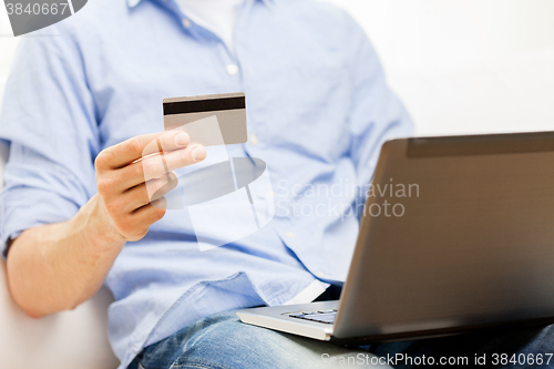 Image of close up of man with laptop and credit card