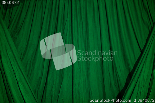 Image of Draped black background cloth lit with green gel