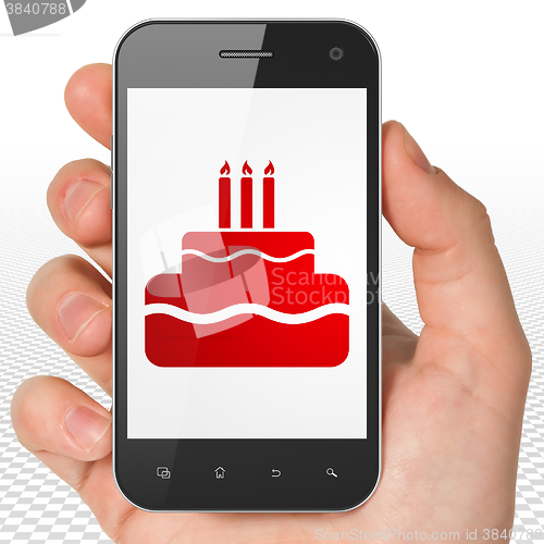 Image of Entertainment, concept: Hand Holding Smartphone with Cake on display