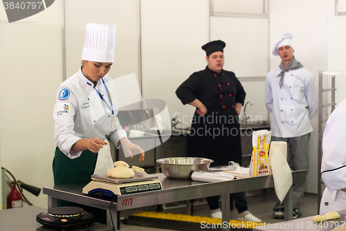 Image of Girl-cook prepares food in competition