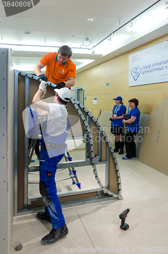 Image of Young workers performs task with gypsum cardboard