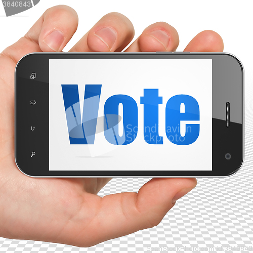 Image of Politics concept: Hand Holding Smartphone with Vote on display