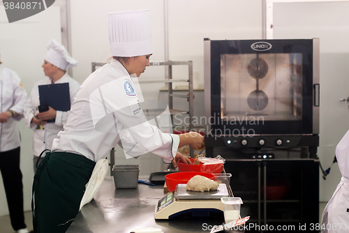 Image of Girl-cook prepares food in competition