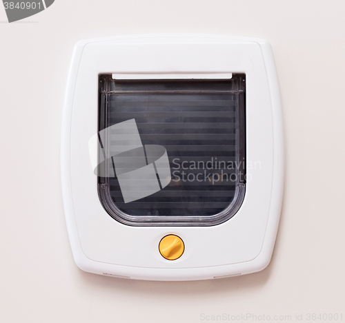 Image of Inside view of a regular white cat flap, cat comming through