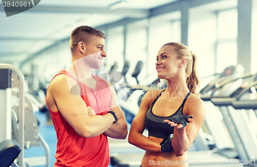 Image of smiling man and woman talking in gym