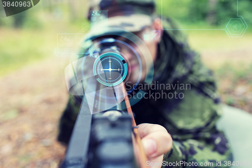 Image of close up of soldier or sniper with gun in forest