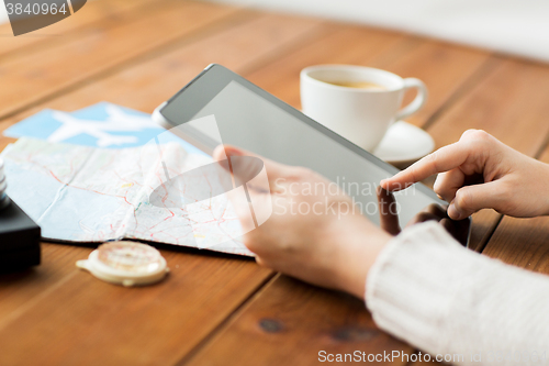 Image of close up of traveler hands with tablet pc and map
