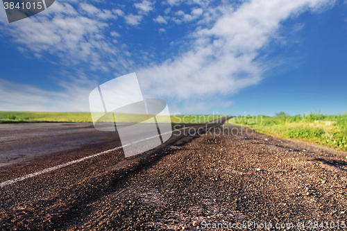 Image of bad asphalt road in summer day