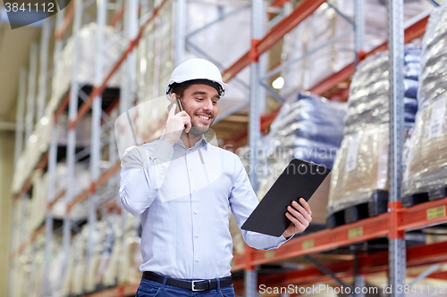 Image of man with clipboard and smartphone at warehouse