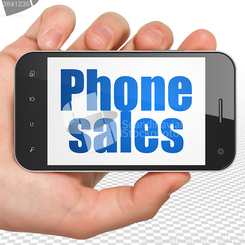 Image of Advertising concept: Hand Holding Smartphone with Phone Sales on display