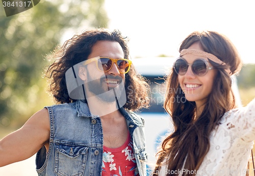 Image of smiling young hippie couple over minivan car