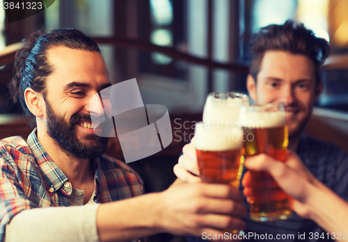 Image of happy male friends drinking beer at bar or pub