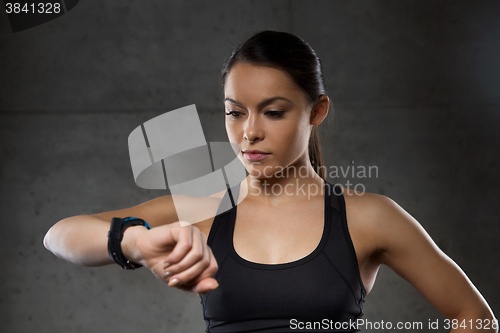 Image of young woman with heart-rate watch in gym