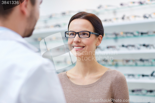 Image of woman in glasses with optician at optics store