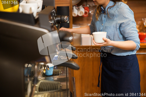 Image of close up of woman making coffee by machine at cafe