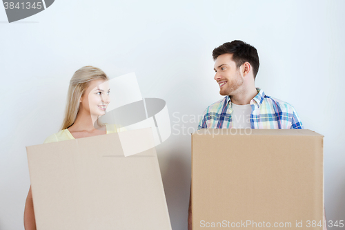 Image of smiling couple with big boxes moving to new home