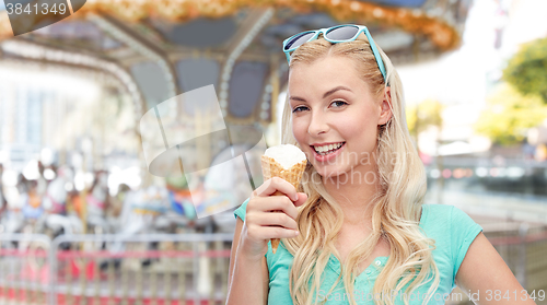 Image of happy young woman in sunglasses eating ice cream