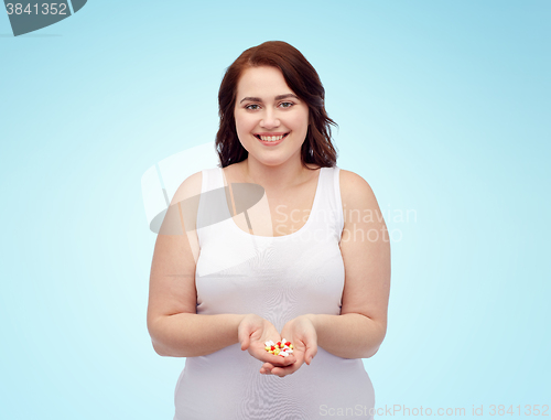 Image of happy plus size woman in underwear with pills