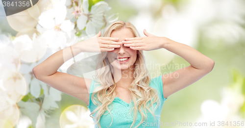 Image of smiling young woman or teen girl covering her eyes