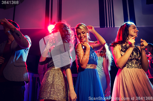 Image of smiling friends dancing in club