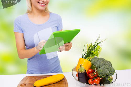 Image of close up of woman with tablet pc cooking at home