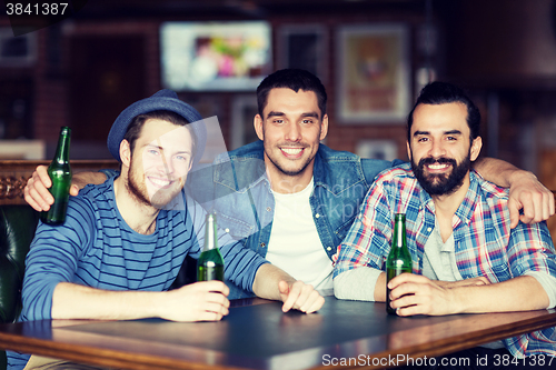 Image of happy male friends drinking beer at bar or pub