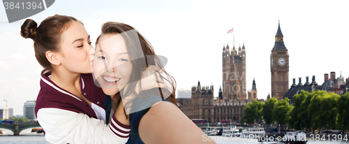 Image of happy teenage girls taking selfie in london