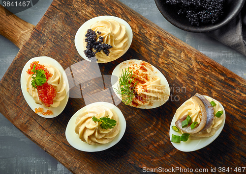 Image of boiled decorative stuffed eggs on wooden cutting board