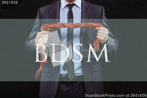 Image of man in business suit with chained hands. handcuffs for sex games. concept of erotic entertainment.