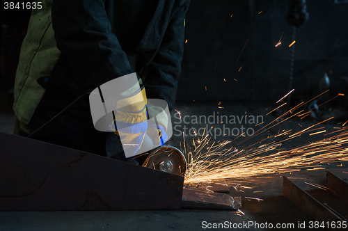 Image of worker works with metal 