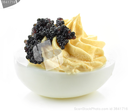 Image of boiled stuffed egg with black caviar