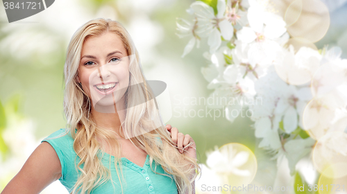 Image of smiling young woman holding her strand of hair