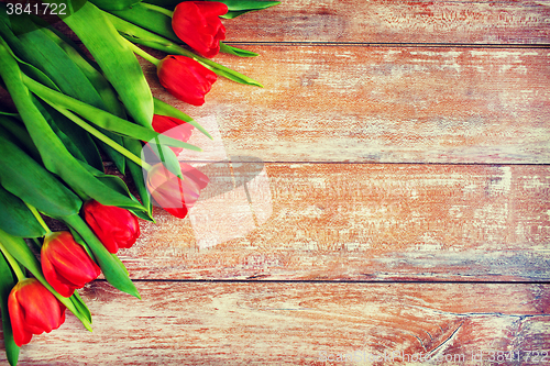 Image of close up of red tulips on wooden background