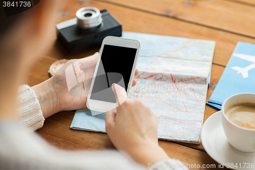 Image of close up of traveler hands with smartphone and map