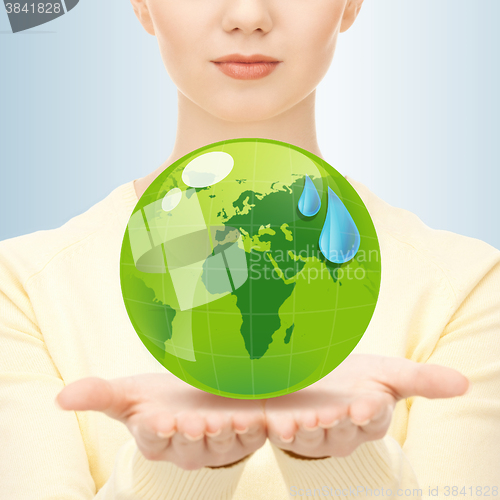 Image of close up of woman holding green globe in her hands