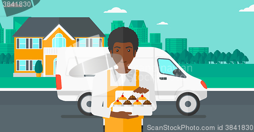 Image of Baker holding box of cakes.