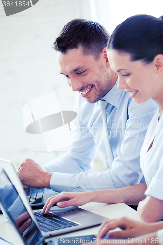 Image of man and woman working with laptop in office