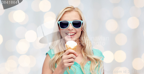 Image of happy young woman in sunglasses eating ice cream