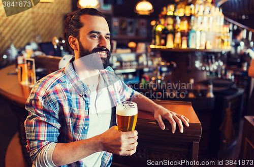 Image of happy man drinking beer at bar or pub